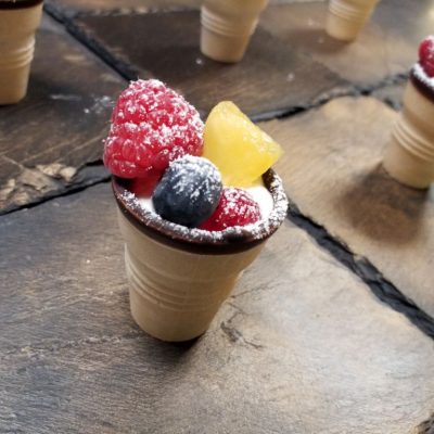 Früchte auf Vanillecreme im Waffelbecher