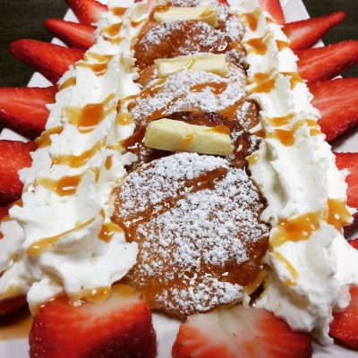 Poffertjes mit Bananen Erdbeeren Sahne und Karamelsauce