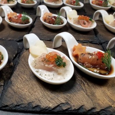 Tastelöffel geräucherte Forelle auf Apfel-Zwiebelsalsa und Lachsröllchen auf Gurke mit Unagi-Ponzusauce